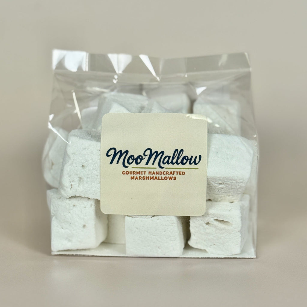 White marshmallows in clear packaging with a "MooMallow" label on the font against a neutral background