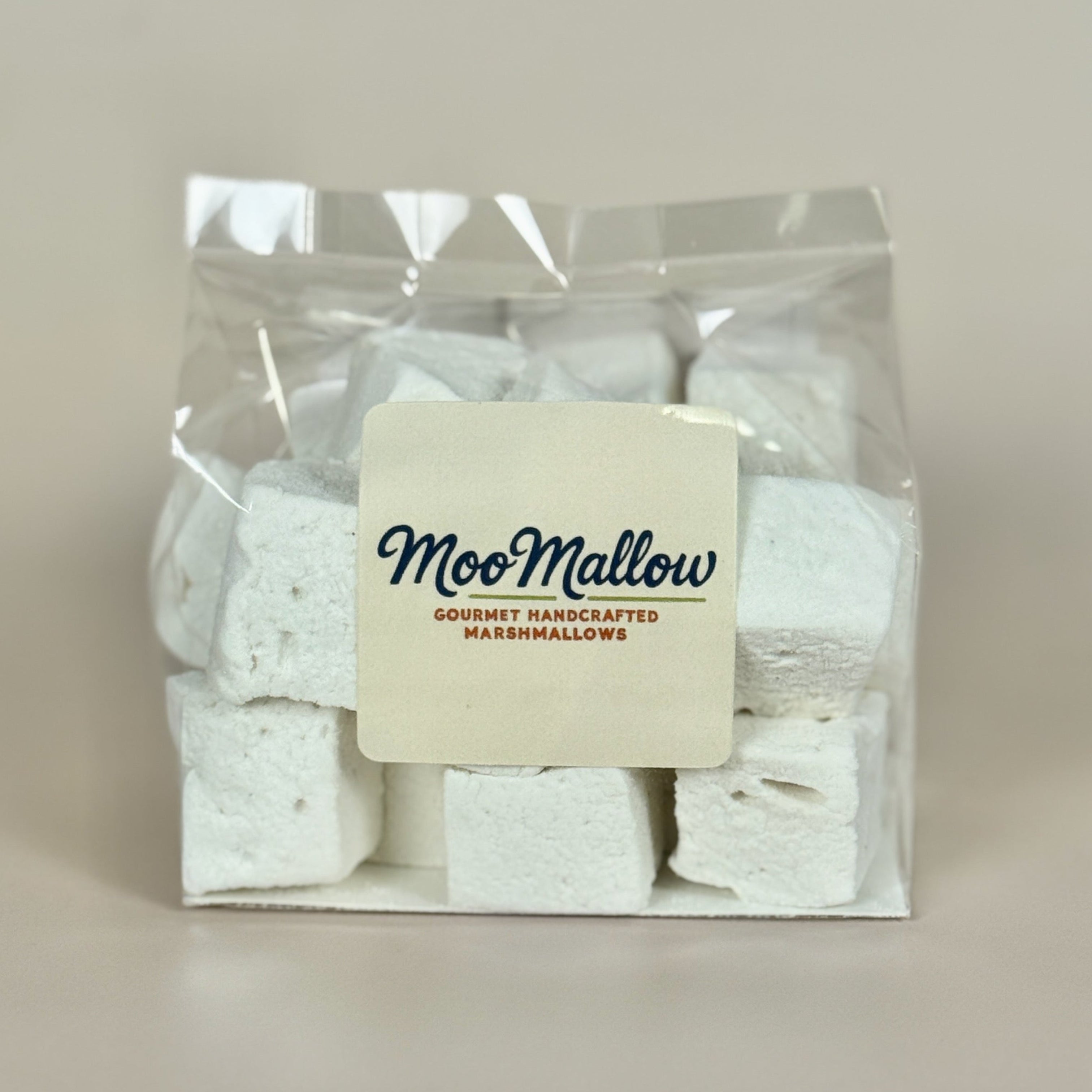 White marshmallows in clear packaging with a "MooMallow" label on the font against a neutral background