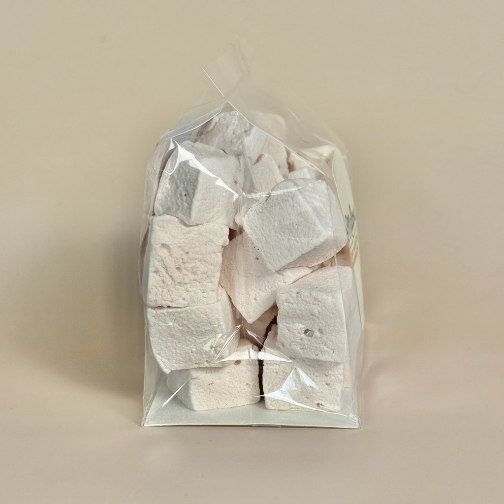 Bag of white and pink marshmallows on a beige background