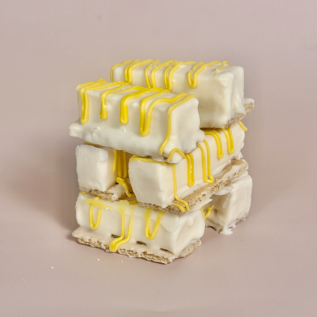 Stack of white and yellow dessert bars on a beige background