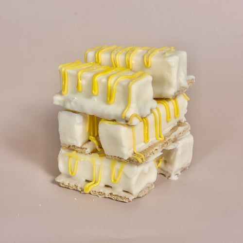 Stack of white and yellow dessert bars on a beige background